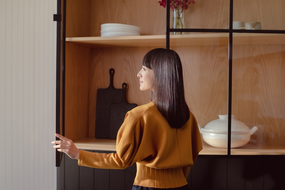 Marie Kondo standing in front of a cabinet